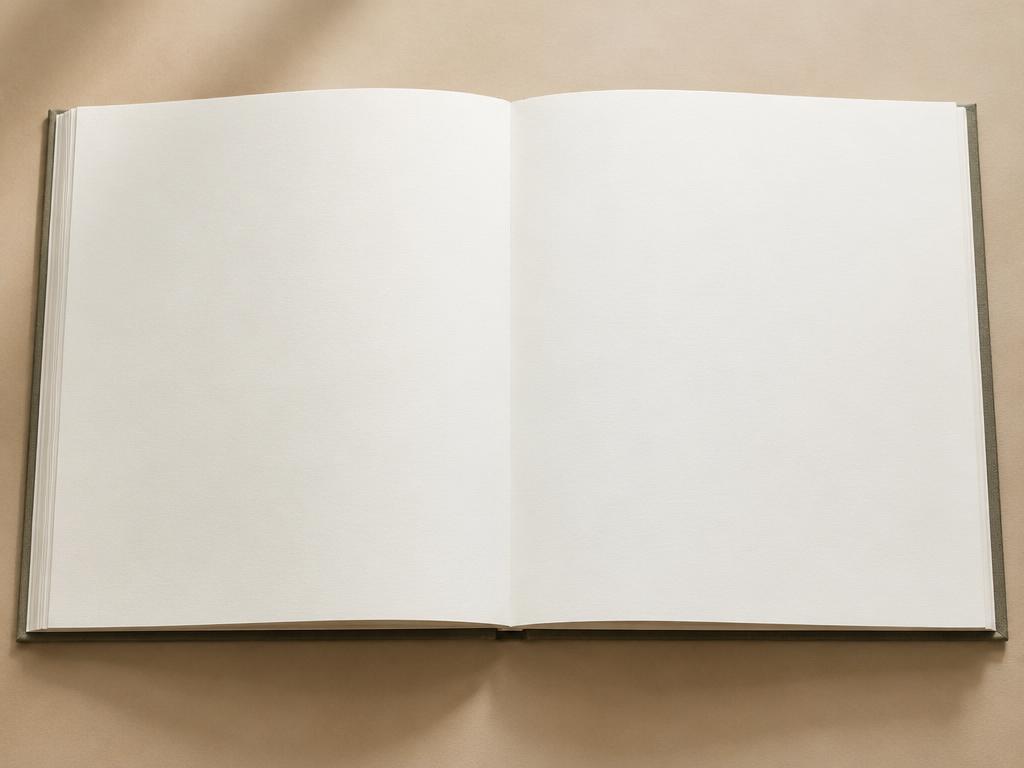 Art book opened completely flat on a table with a blank spread